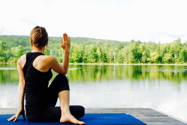 Woman doing yoga at the lake