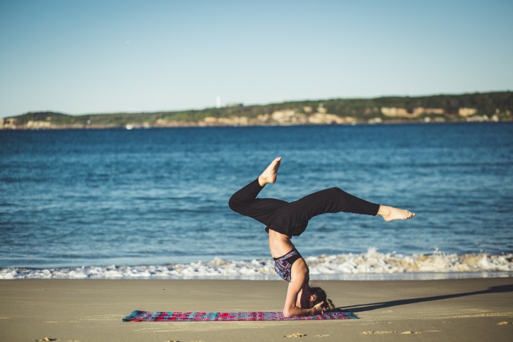 Woman doing yoga at the beach