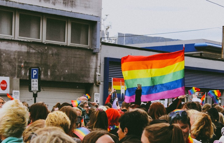 Crowd holding multicolored flag