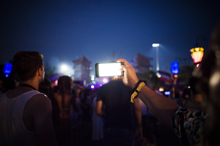 Phone in hand filming night festival