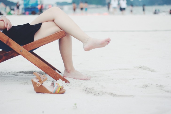 Women sitting at the beach barefoot
