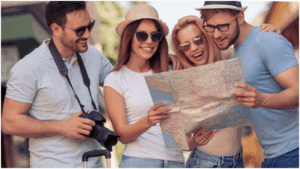 a group of four friends who are tourists looking at a map together