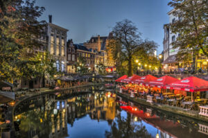 Utrecht, The Netherlands, September 30, 2017: houses, trees and outdoor cafes reflecting in the Oude Gracht (Old Canal) on a beautiful evening in autumn