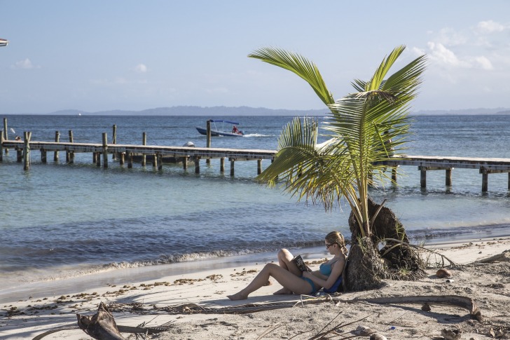 A girl reading a book on the beach