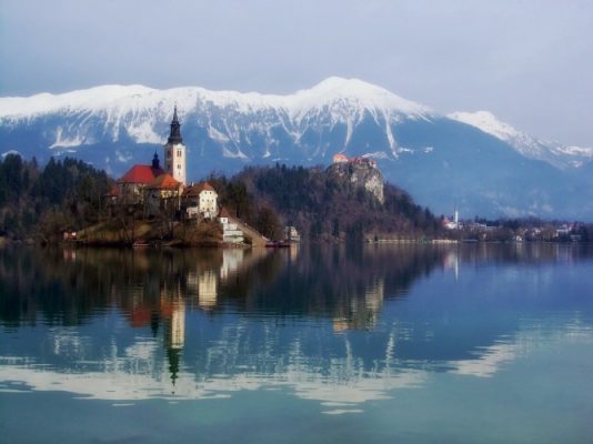 Snowy mountain peaks reflecting in the water