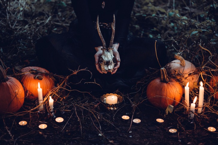 Goat skull, pumpkins and candles