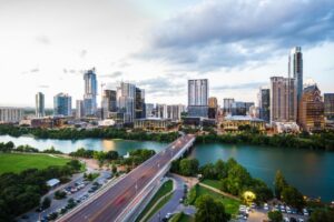 Austin skyline in Texas, prominently featuring the Colorado River and the Congress Avenue Bridge