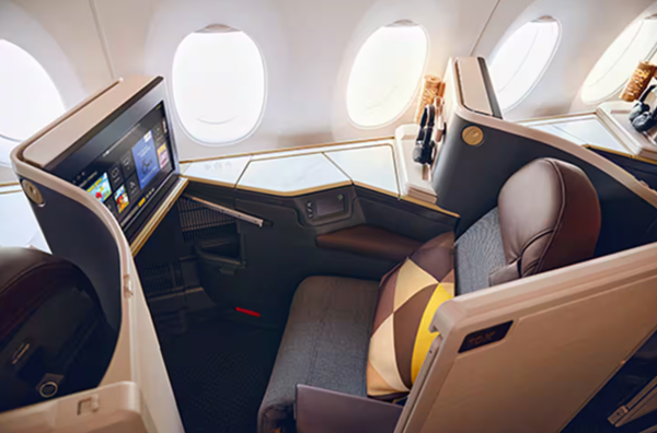 The interior of an Etihad Airways business class cabin, specifically featuring their new Business Class Suites on the Airbus A350-1000 aircraft.