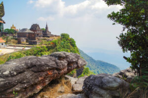 Kampot Buddhist temple Wat Sampov Pram and view on bottom of mountain Bokor and coast of gulf of Siam - a coastal line of Kampot. Cambodia, Preah Monivong Bokor National Park