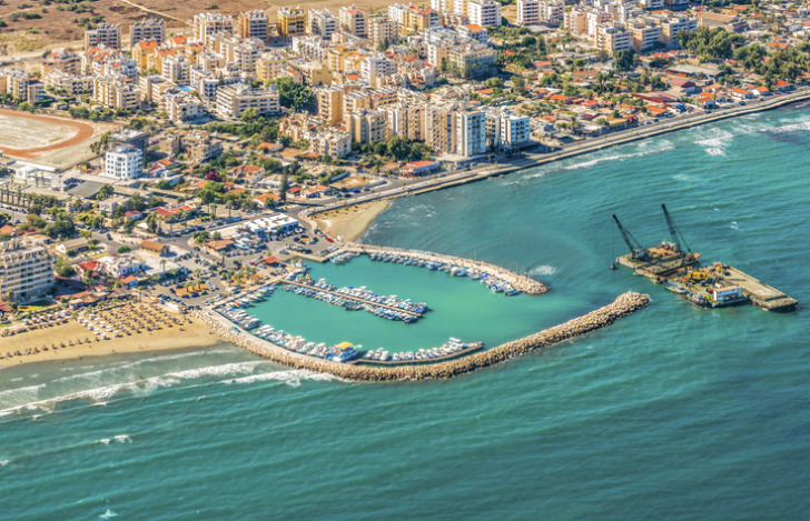 Sea port city of Larnaca, Cyprus. View from the aircraft to the coastline, beaches, seaport and the architecture of the city of Larnaca.