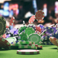 Poker chips falling on green felt roulette table, blur casino interior background. 3d illustration