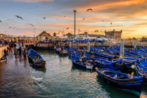 Beautiful sunrise in Essaouira port. Traditional blue fishing boats.