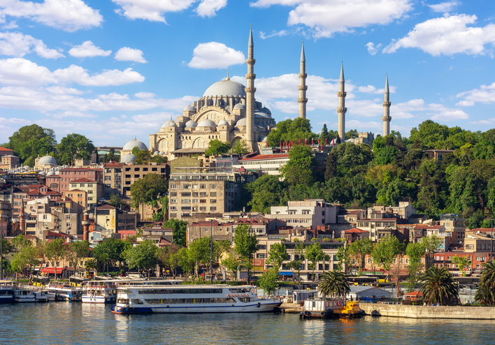 Istanbul cityscape with Suleymaniye mosque and cruise boat in Golden Horn bay, Turkey