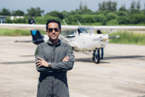 Pilot in uniform at airport. Asian Confident male pilot in uniform and checking flight plan