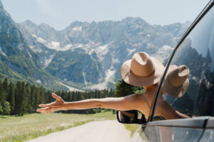 Happy beautiful woman traveling by car in mountains. Travel nature outdoors