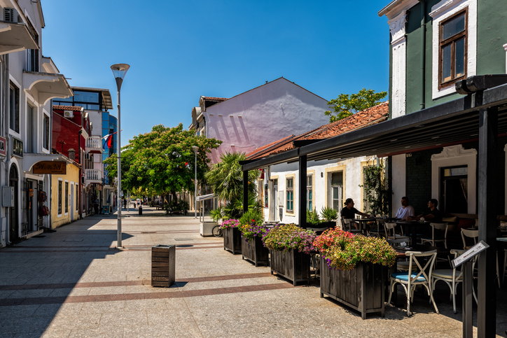 Men people eating outside at outdoor sitting area, dining in summer on Hercegovacka pedestrian street, Podgorica