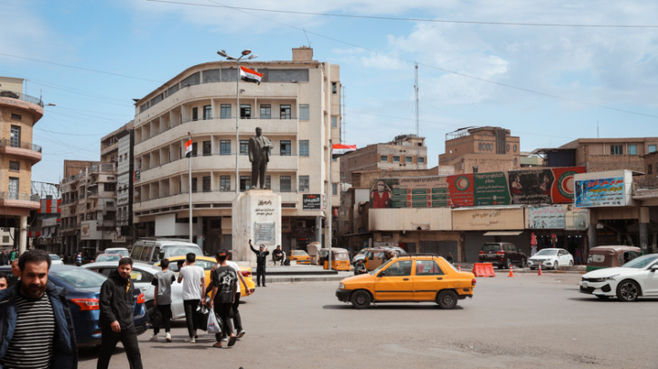 Busy intersection in Baghdad Iraq with statue