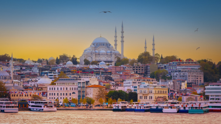 Tourboat in the Bosphorus by beautiful evening scene at Suleymaniye Mosque of Istanbul, Turkey