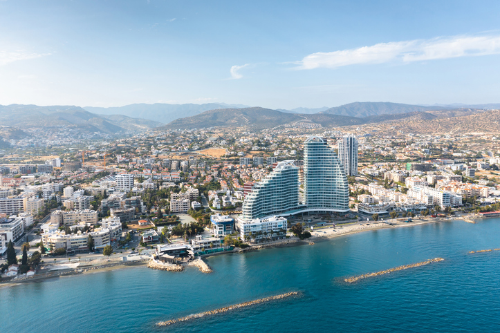 Aerial view of Limassol cityscape featuring modern architecture, coastline and mountains in Cyprus