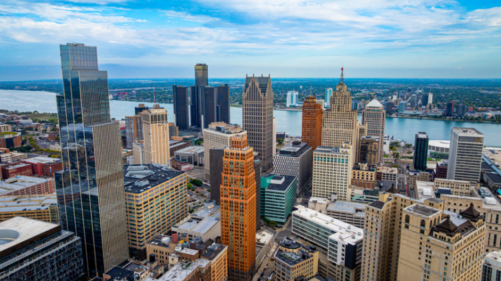 Detroit downtown skyline and river. Detroit skyscrapers, the Detroit River, and the skyline under partly cloudy sky.