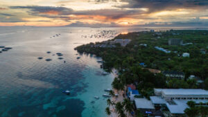 sunset aerial low angle drone view of Alona Beach on Panglao Island, Bohol, famous tourist travel destination