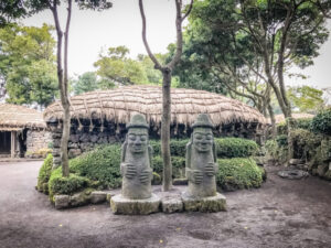 Twin Jeju idols (Dolharubang, the "grandfather stones" ) in Seongeup Folk Village, Jeju Island, Korea