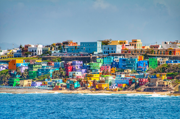 Bright colorful houses line the hills overlooking the beach in San Juan, Puerto Rico