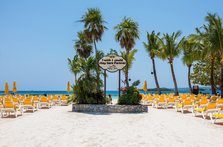 White sand beach with yellow chaise lounges