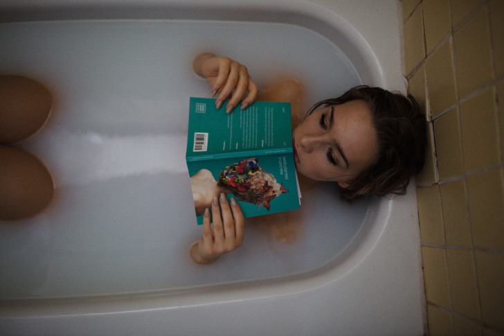 Girl reading in a tub