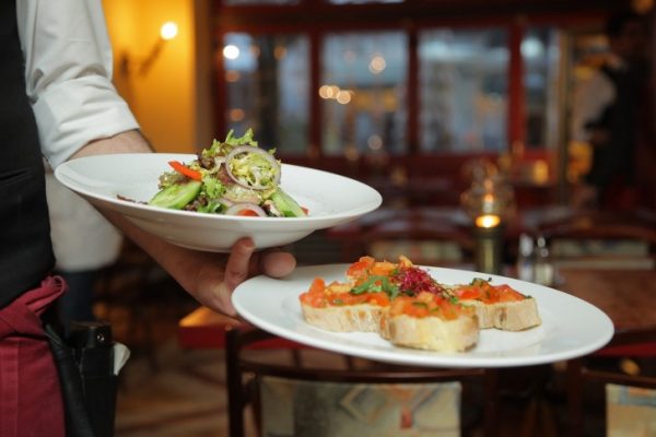 A waiter taking food at a restaurant