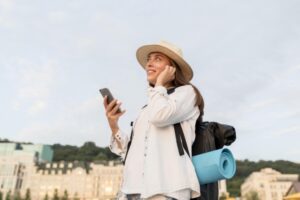Side view woman with backpack smartphone traveling
