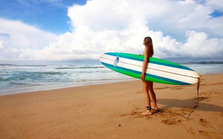 Girl with a surf on a beach