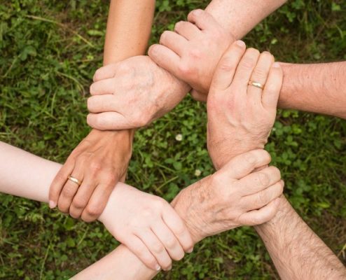 Friends holding each other arms