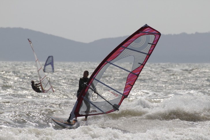 Three windsurfers on the waves